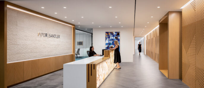 Reception area featuring minimalist design with a sleek, marble desk, warm wooden wall slats, and dynamic chevron-patterned flooring. Recessed lighting accentuates a textured feature wall and contemporary art adds a pop of color.