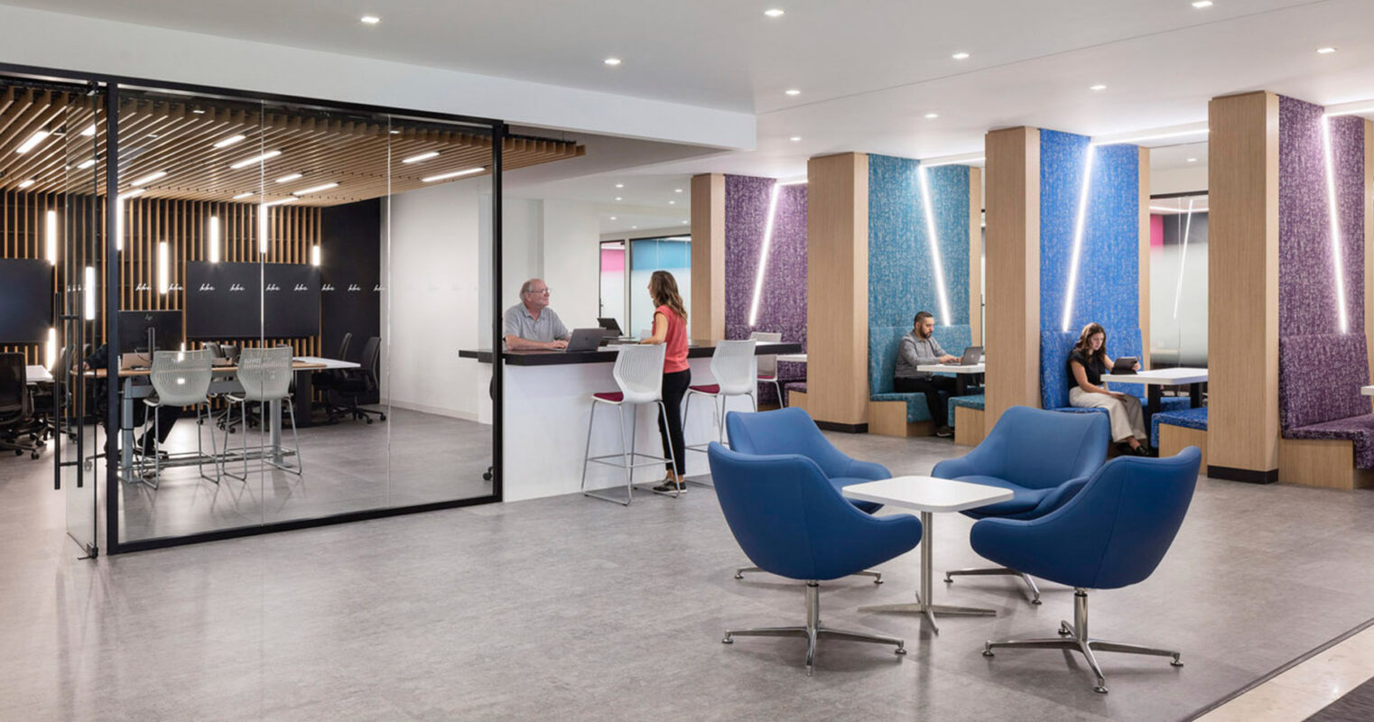 An office with blue chairs and a glass wall, creating a modern and professional workspace.