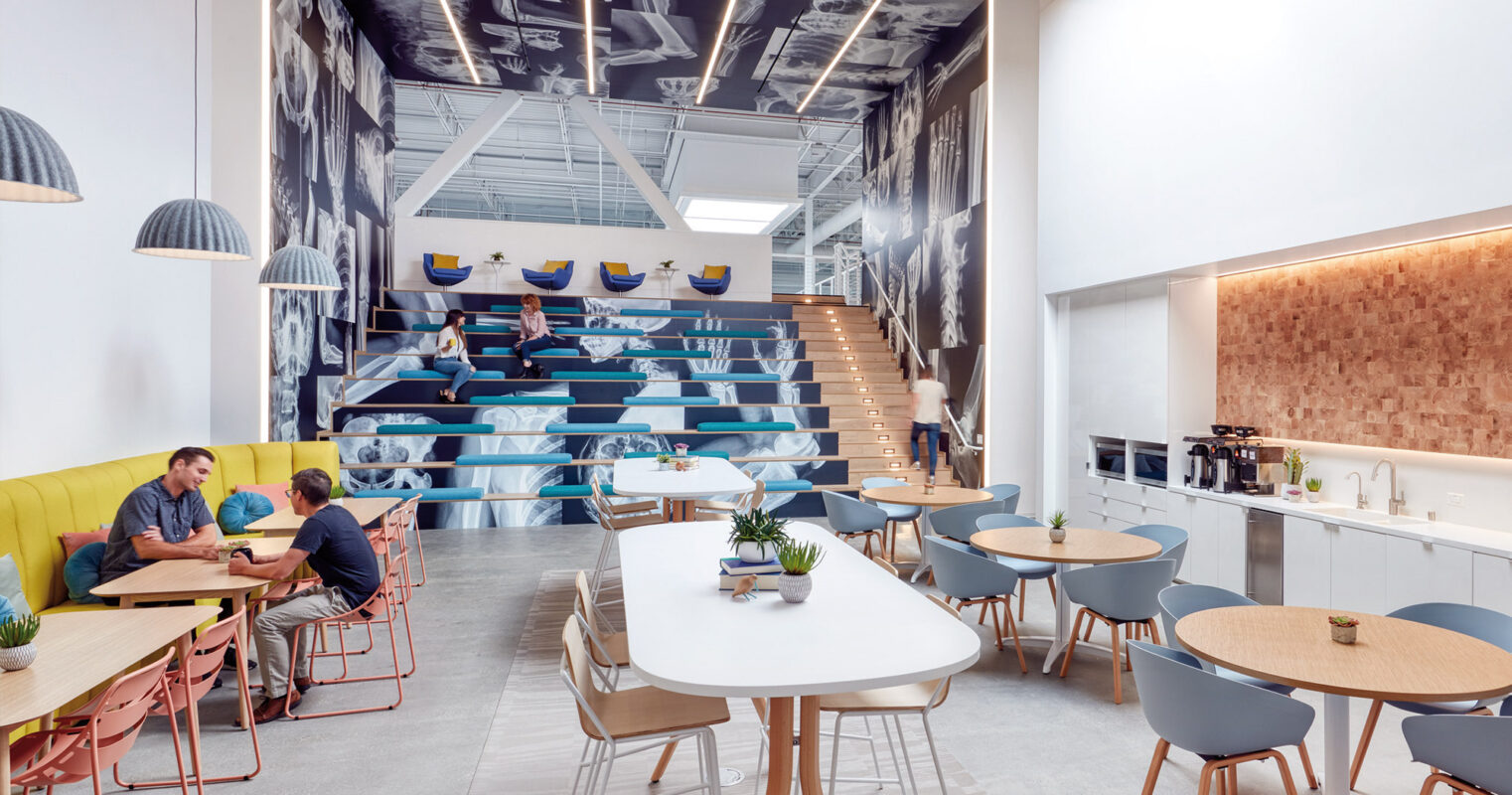 A modern and stylish office break room with a staircase seating area, where coworkers can enjoy a casual meeting or a coffee break.