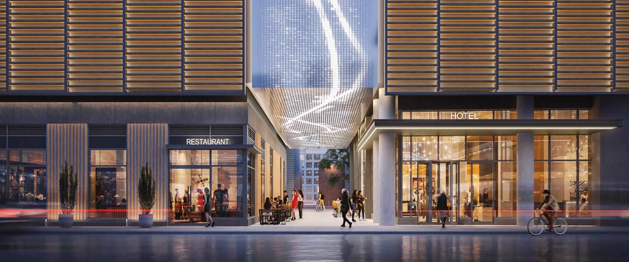 Modern building exterior at twilight with illuminated facade featuring dynamic light installation. Ground level showcases transparent entrances to a restaurant and hotel, with pedestrians and a cyclist indicating vibrant urban life.