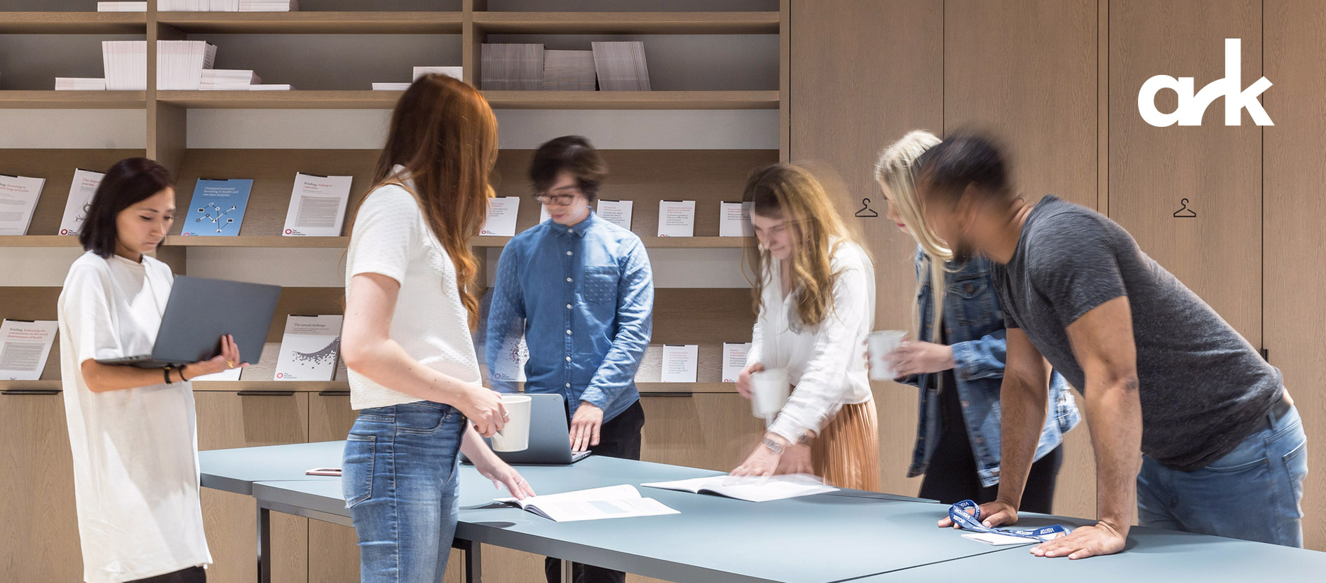 Strategy team gathered around a table with papers, engaged in discussion and collaboration.