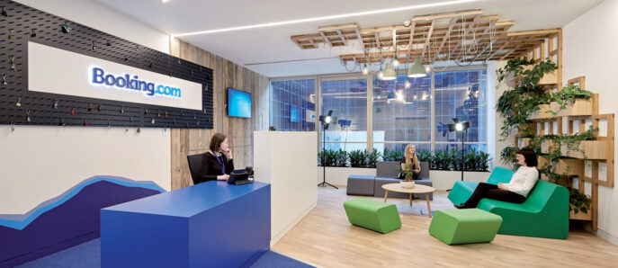 Bright, modern office reception area with a contemporary design featuring an illuminated logo on textured black wall, angular front desk, wood slat ceiling details, and vibrant green seating accents, fostering a dynamic and welcoming environment.