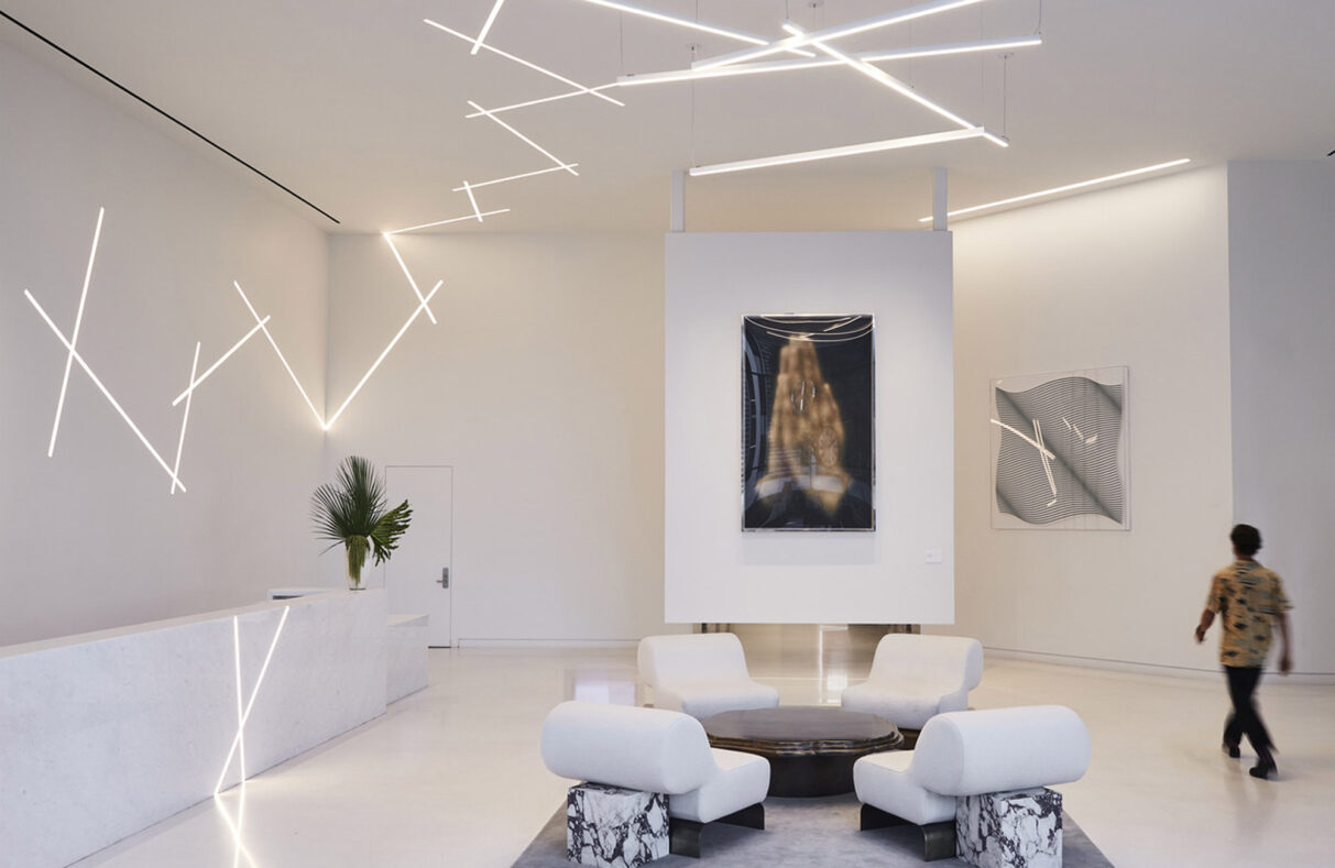 A modern and minimalist interior of a spacious living area, highlighted by sleek design, unique lighting fixtures, and contemporary art pieces that evoke a sense of luxury and innovation.