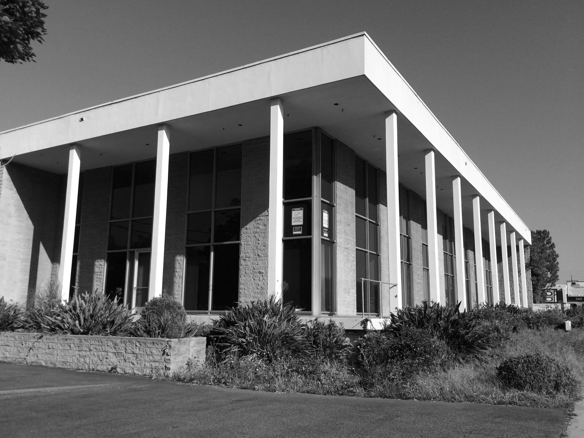 Exterior corner of former warehouse building with supporting columns around the perimeter.