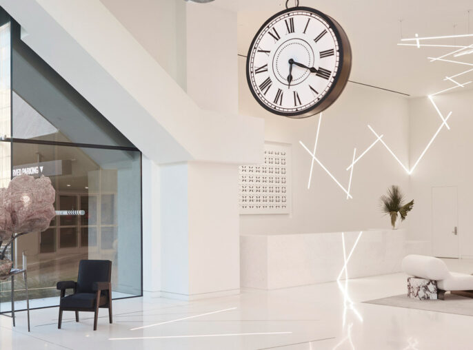 Modern interior showcasing a minimalist design with an open layout featuring sleek white flooring, angular lighting fixtures, contrasting stark black furnishings, and statement oversized hanging clock enhancing the contemporary aesthetic.