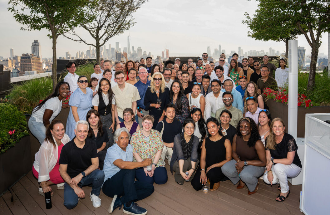 HLW team members gathered on a landscaped rooftop terrace with the New York City skyline in the background, highlighting workplace diversity, inclusion, and community within a collaborative design firm.